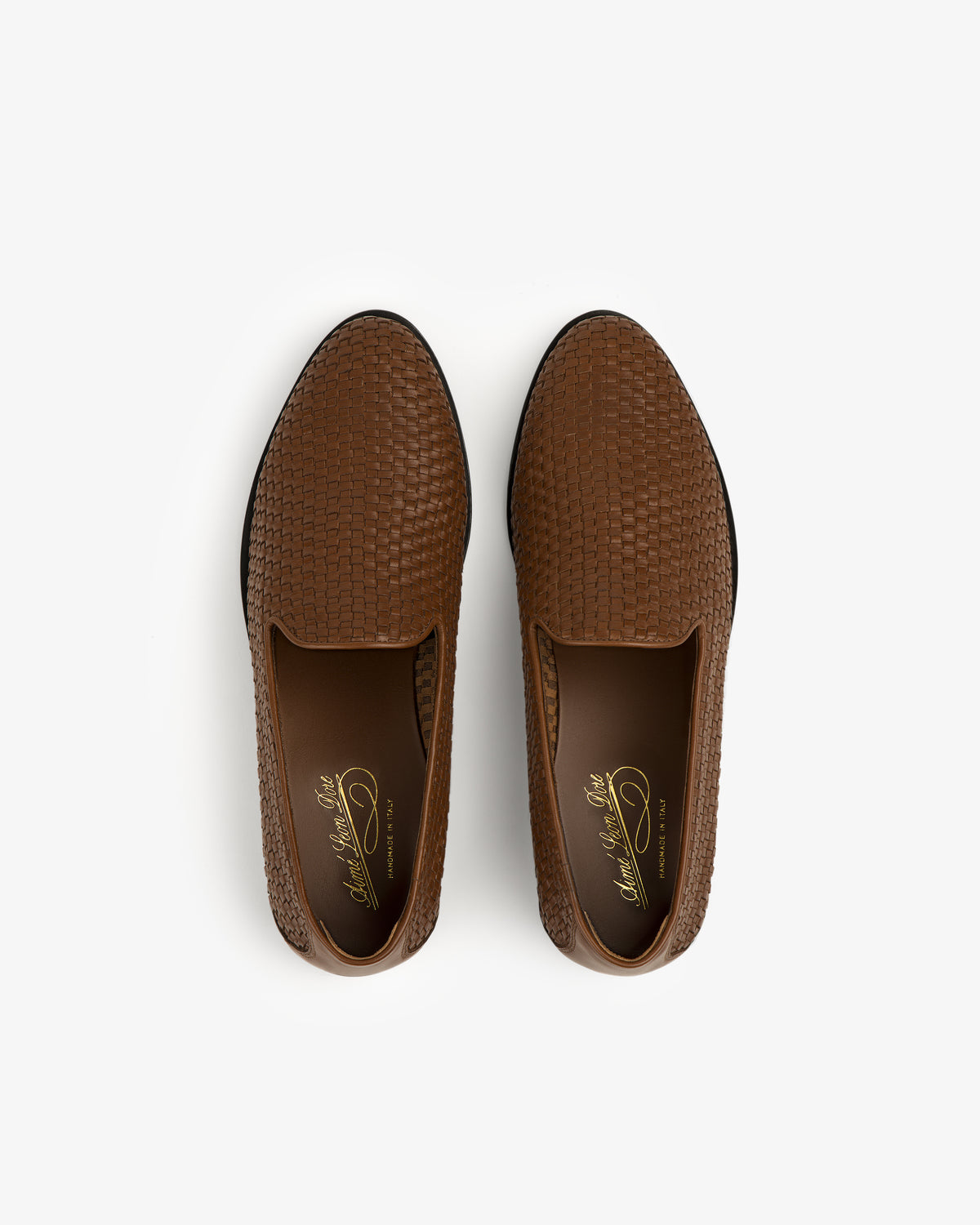 The Leather Raffia Loafer: brown, textured slip-ons with a woven pattern, shown from above on a white background.