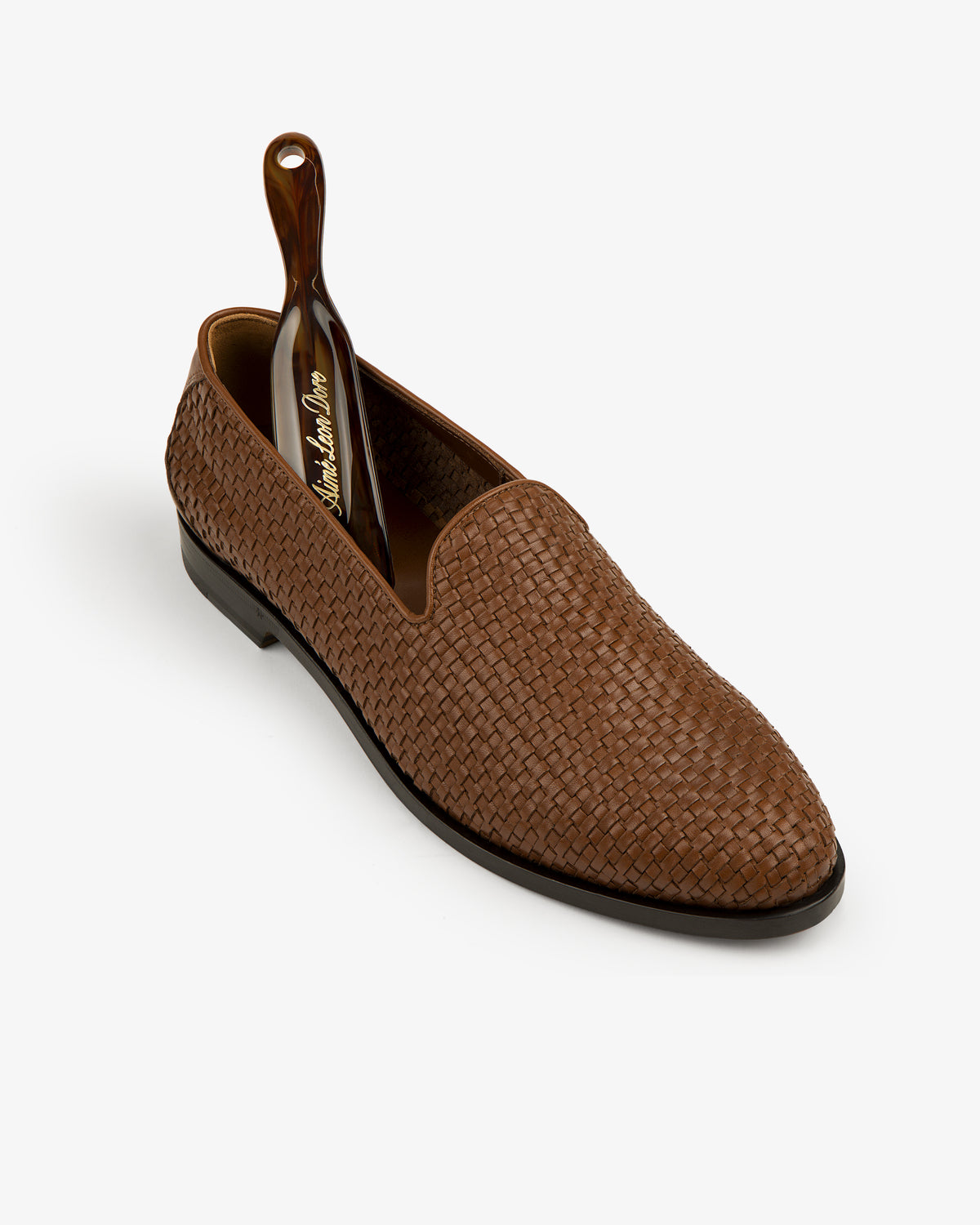 Leather Raffia Loafer in brown with a black shoehorn inside, shown on a white background.