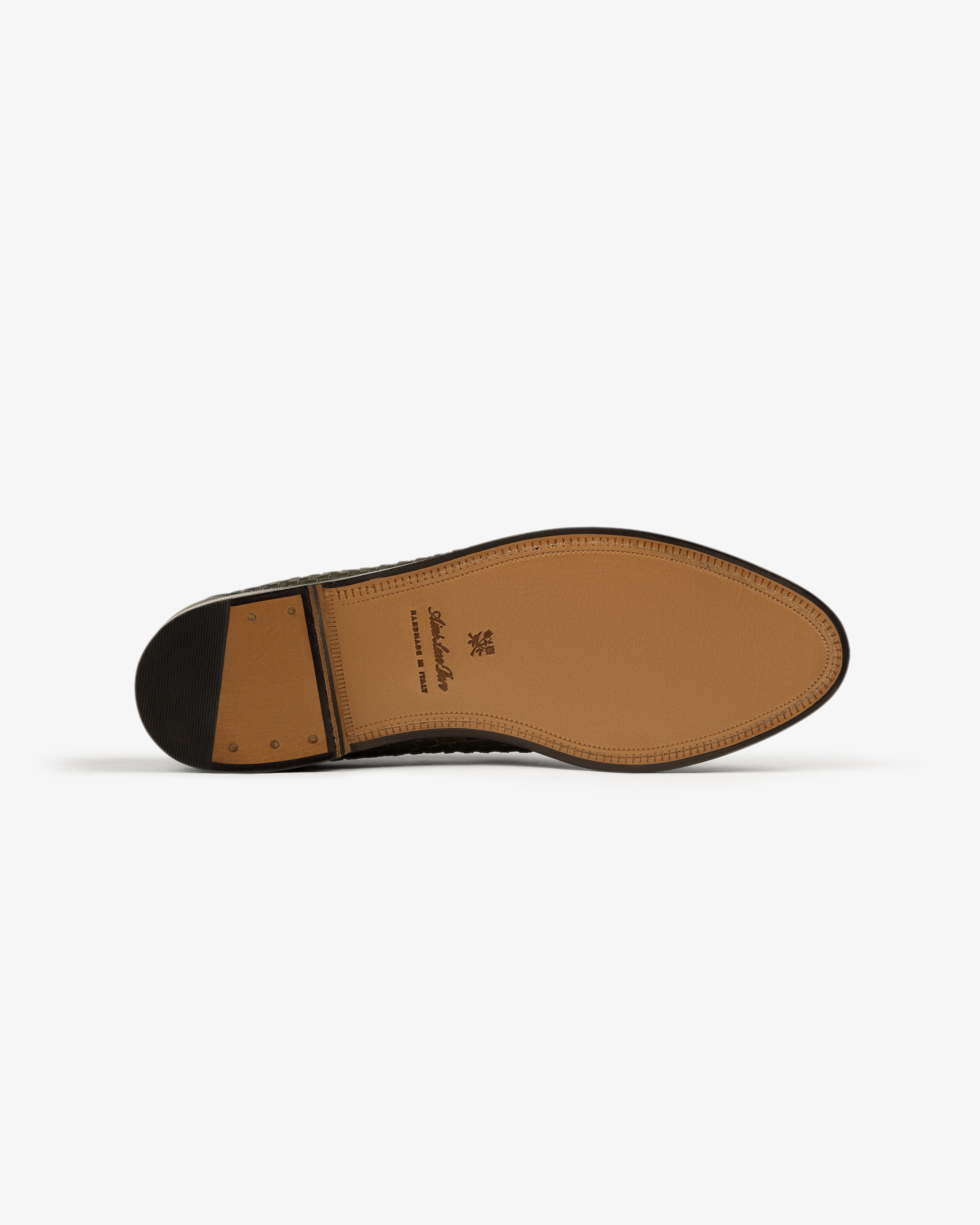 Tan leather and black heel detailing on the sole of the Leather Raffia Loafer, shown from the bottom.