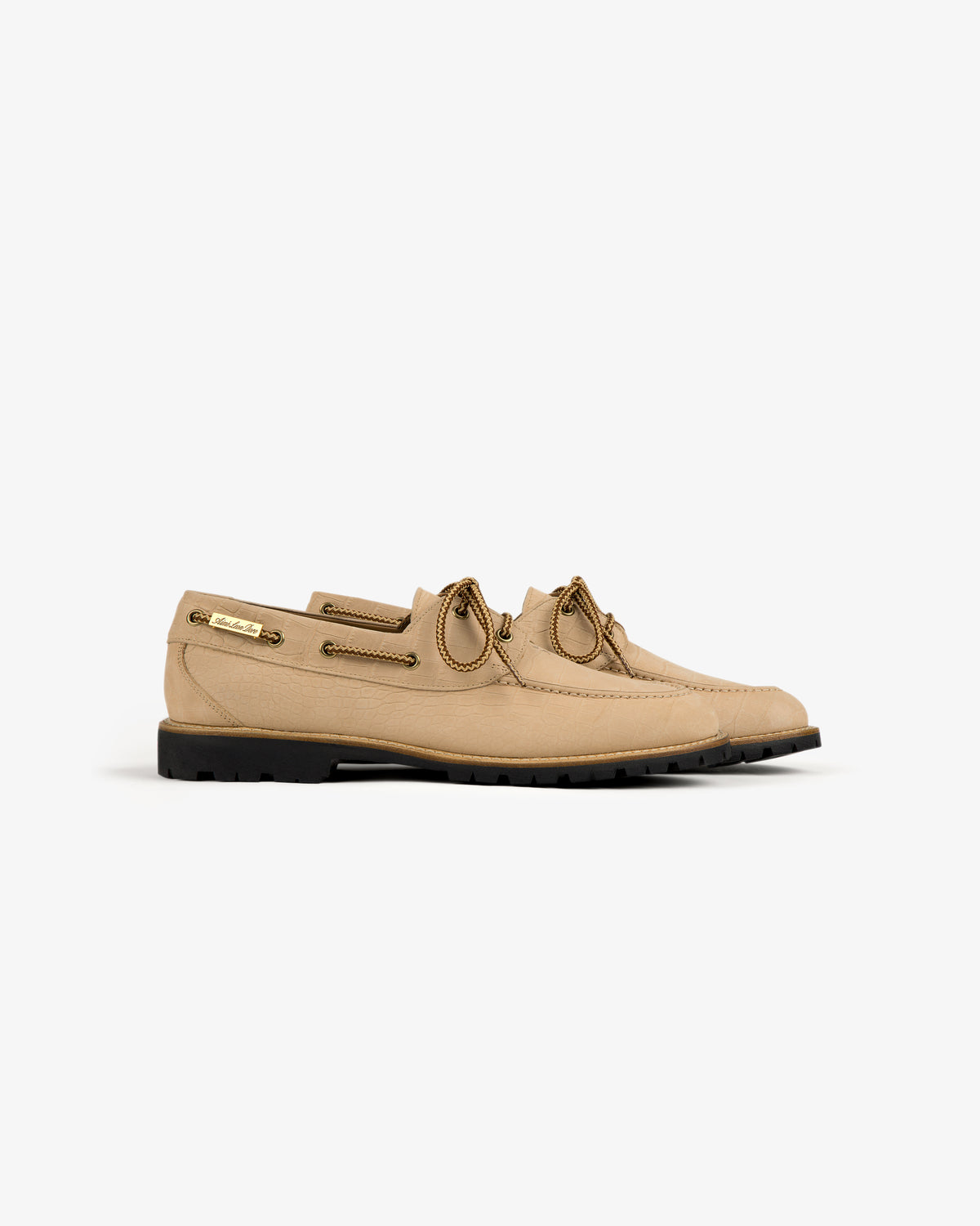 Pápia Boat Shoe in tan leather with brown laces, stitching details, and black rubber sole, shown from the side.