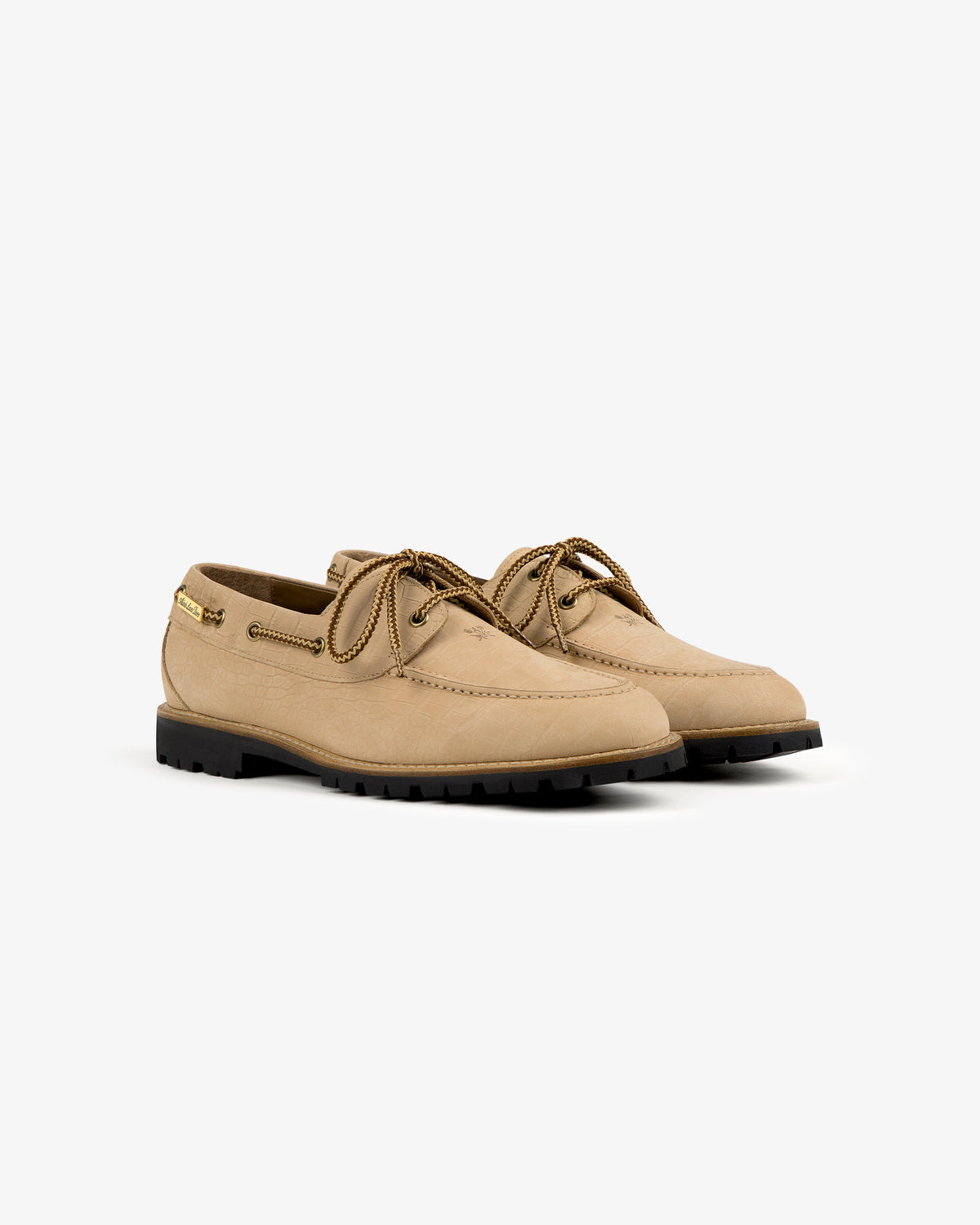 Pápia Boat Shoe: light brown leather lace-ups with black rubber soles, shown on a white background.