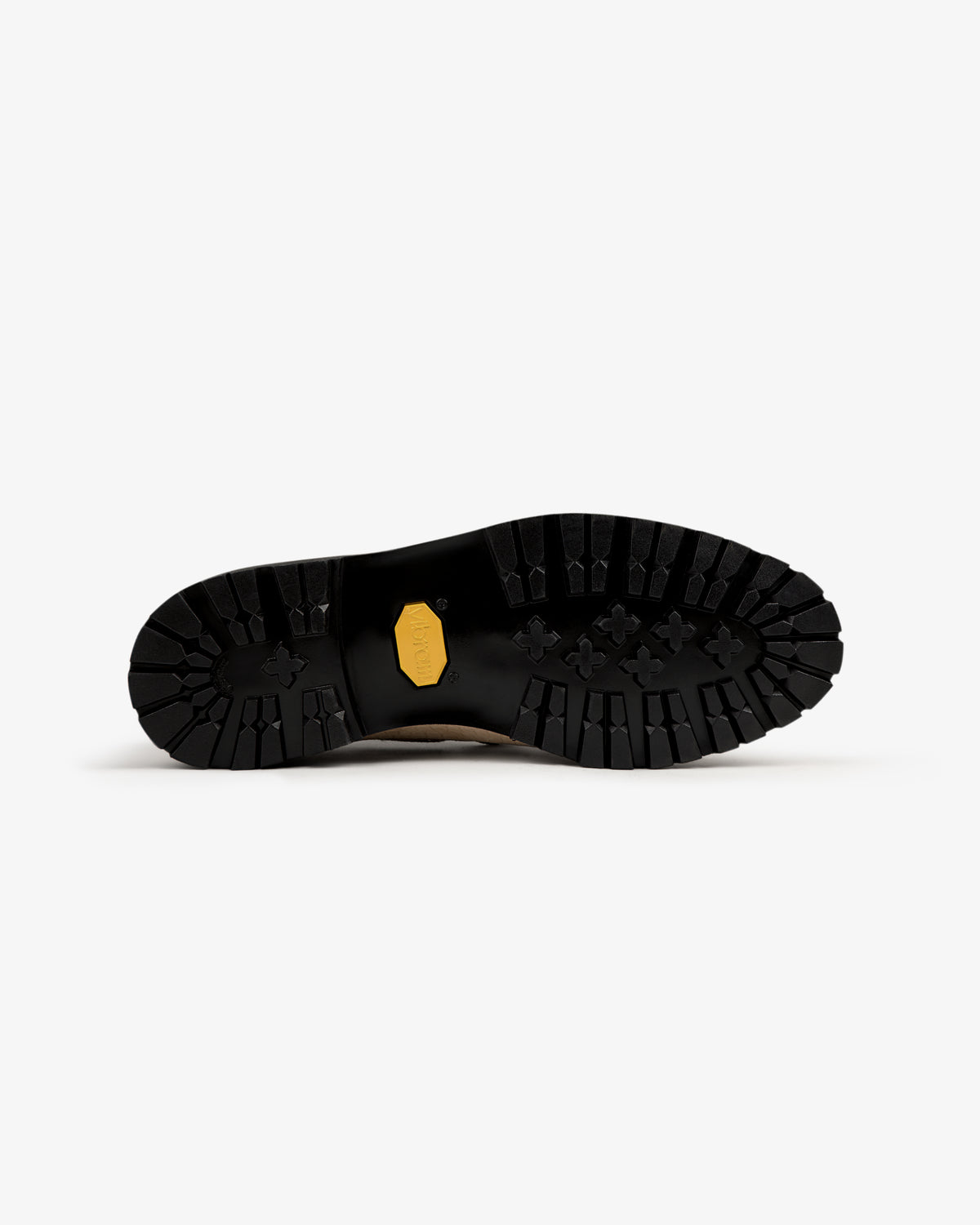 Black rugged sole of Pápia Boat Shoe with deep treads and a yellow hex logo on white background.
