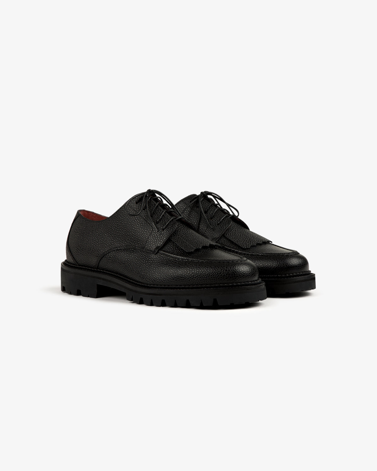 A pair of Leather Lug Sole Derby shoes with a black textured finish and thick, rugged soles on a plain background.