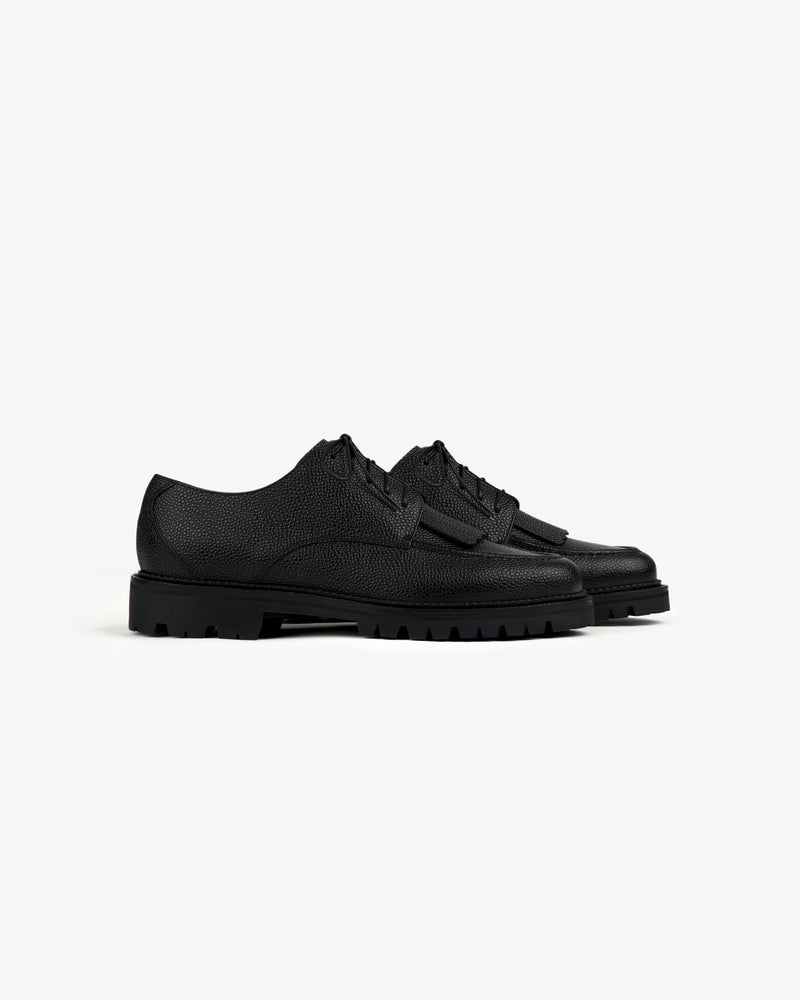 Leather Lug Sole Derby in black textured leather with thick rubber soles on a white background.