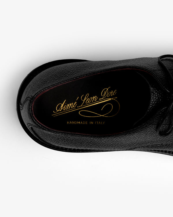 Top-down view of a black Leather Lug Sole Derby with gold branding printed on the insole.