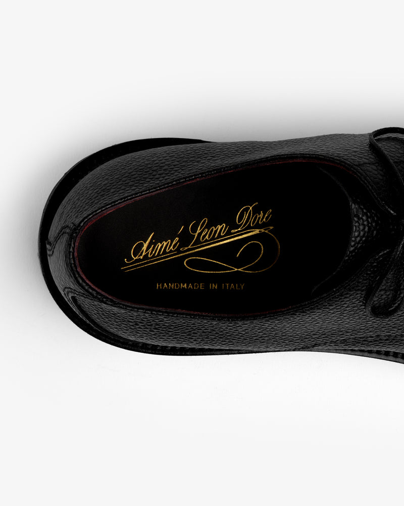 Top-down view of a black Leather Lug Sole Derby with gold branding printed on the insole.