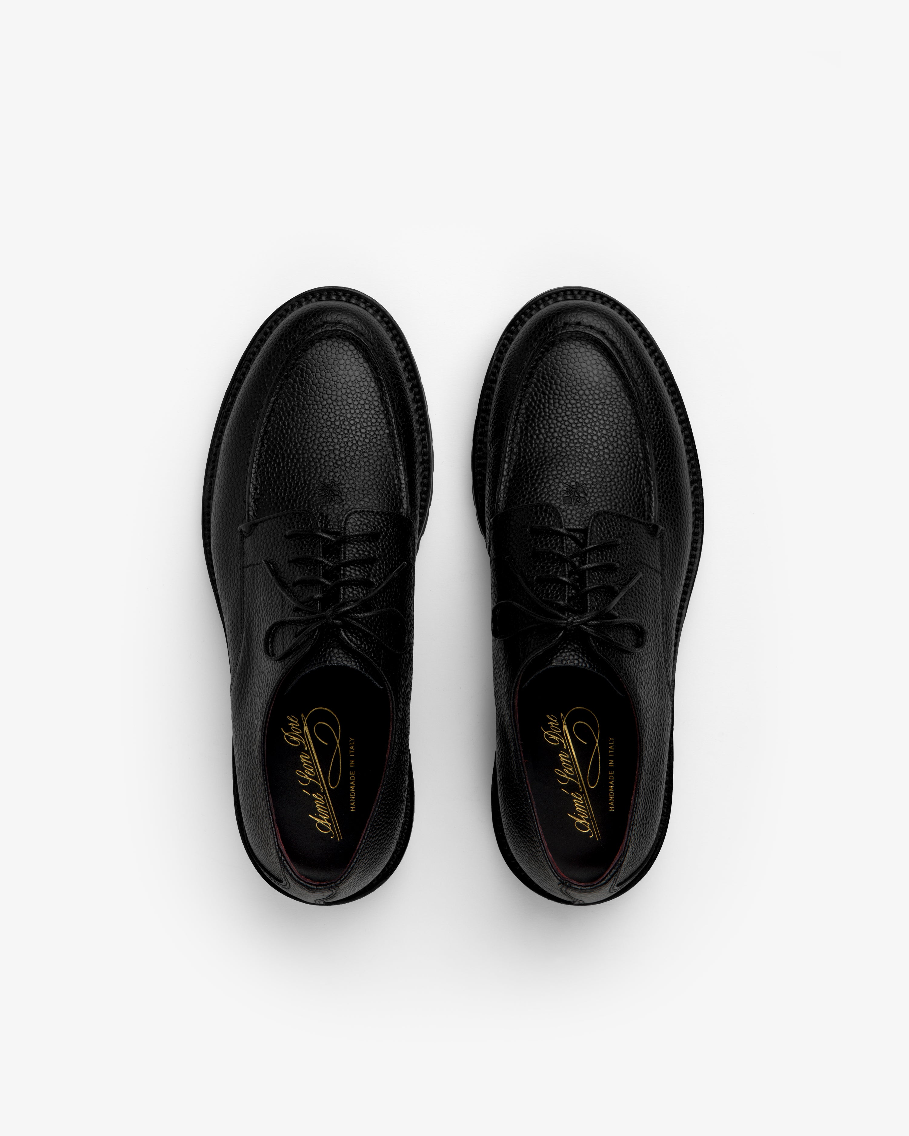 Pair of black textured Leather Lug Sole Derby shoes with thick lug soles, viewed from above.