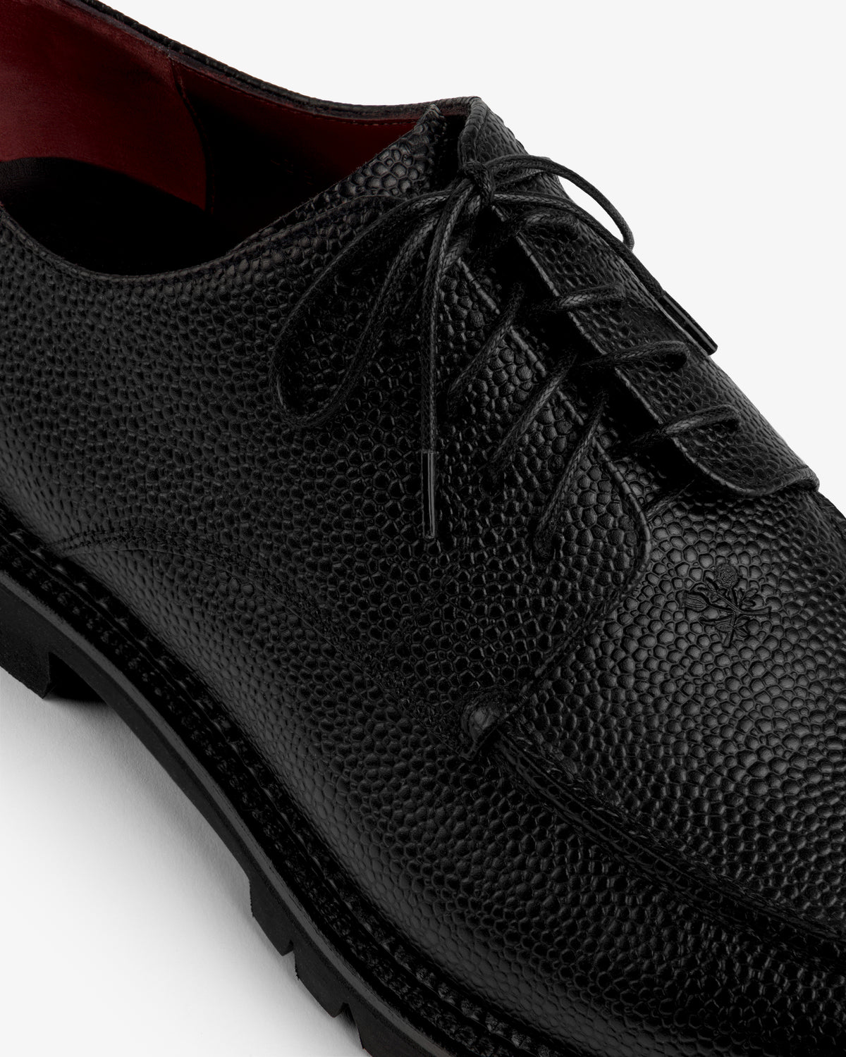 Leather Lug Sole Derby: black textured leather lace-up shoe with a thick lug sole and maroon interior.