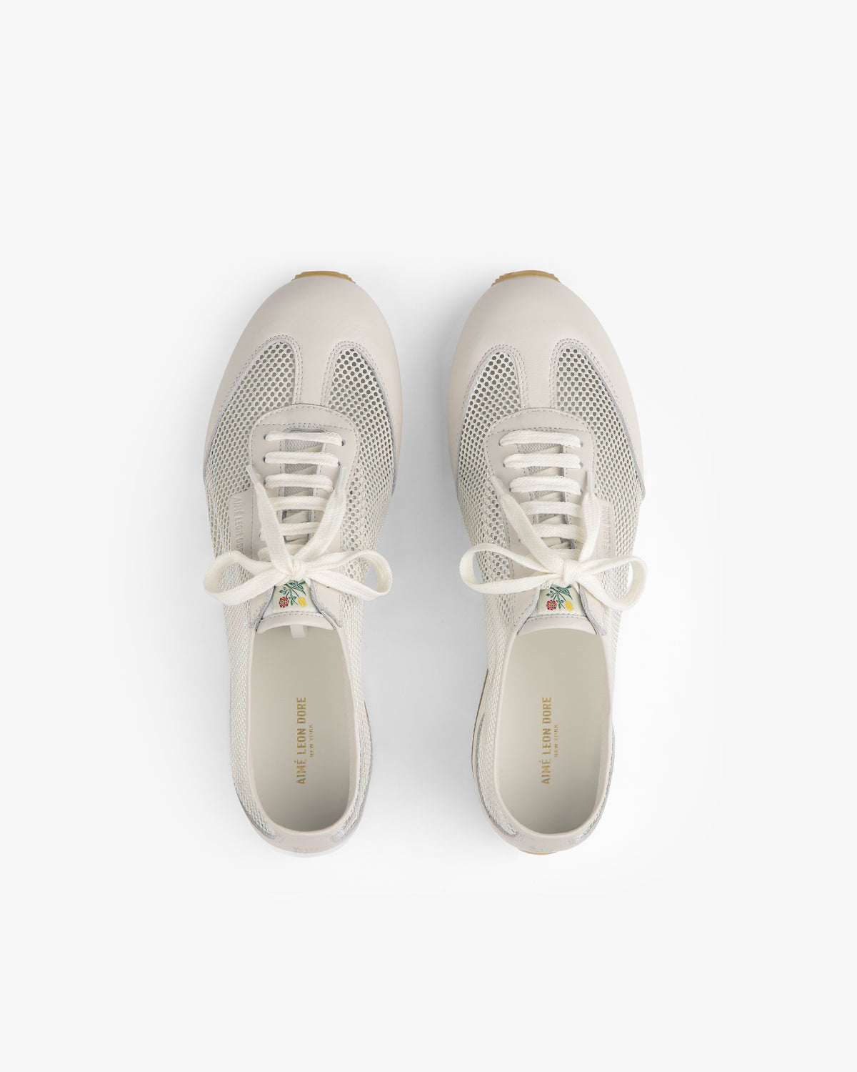 Top view of Low Profile Mesh Trainer sneakers in white mesh and leather with laces on a plain white background.