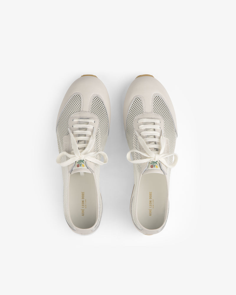 Top view of Low Profile Mesh Trainer sneakers in white mesh and leather with laces on a plain white background.