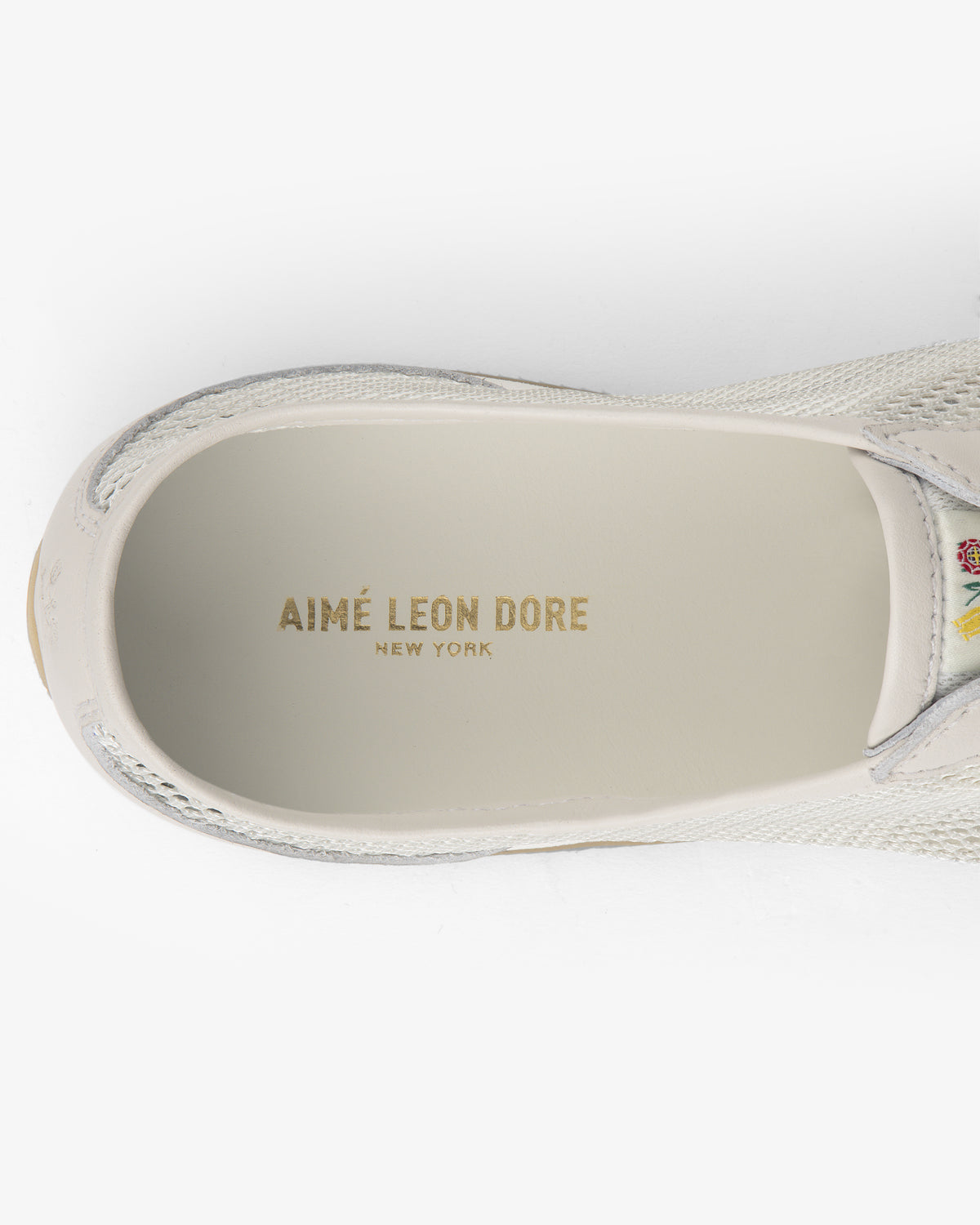 Top view of the Low Profile Mesh Trainer with AIMÉ LEON DORE NEW YORK printed in gold on the insole.