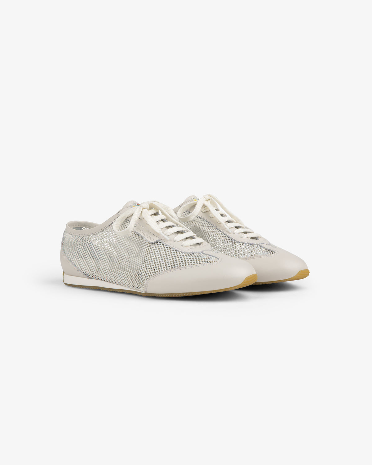 The Low Profile Mesh Trainer features white mesh, cream laces, and beige soles on a plain white background.