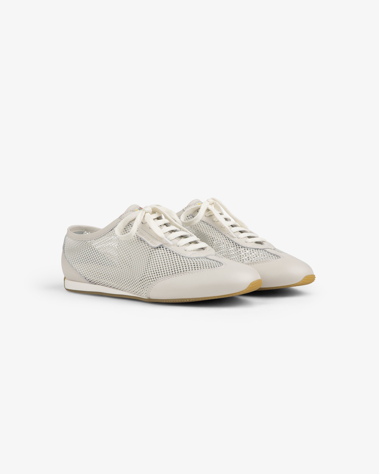 The Low Profile Mesh Trainer features white mesh, cream laces, and beige soles on a plain white background.