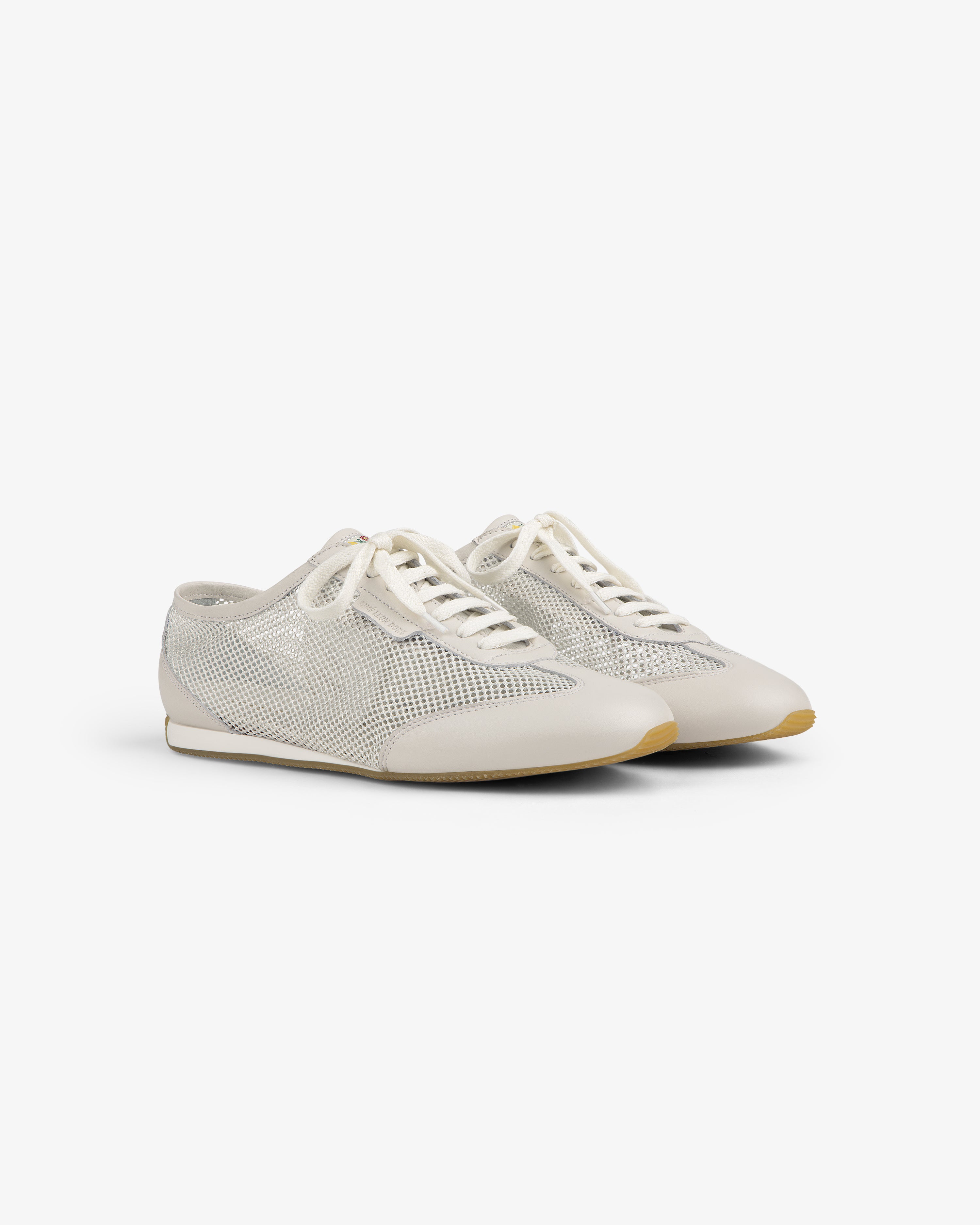 The Low Profile Mesh Trainer features white mesh, cream laces, and beige soles on a plain white background.