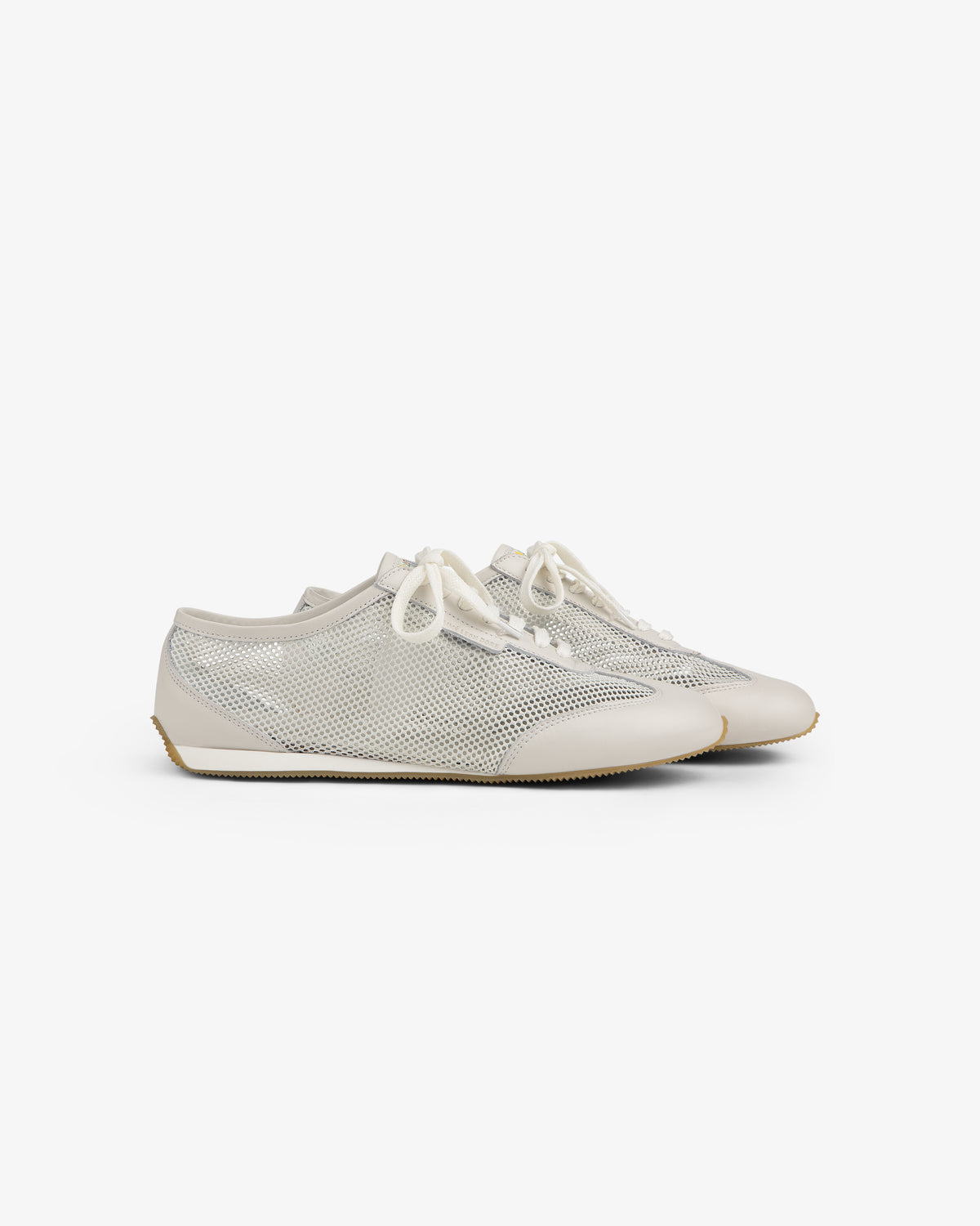 Low Profile Mesh Trainer: White mesh sneakers with cream soles and laces, displayed on a plain background.