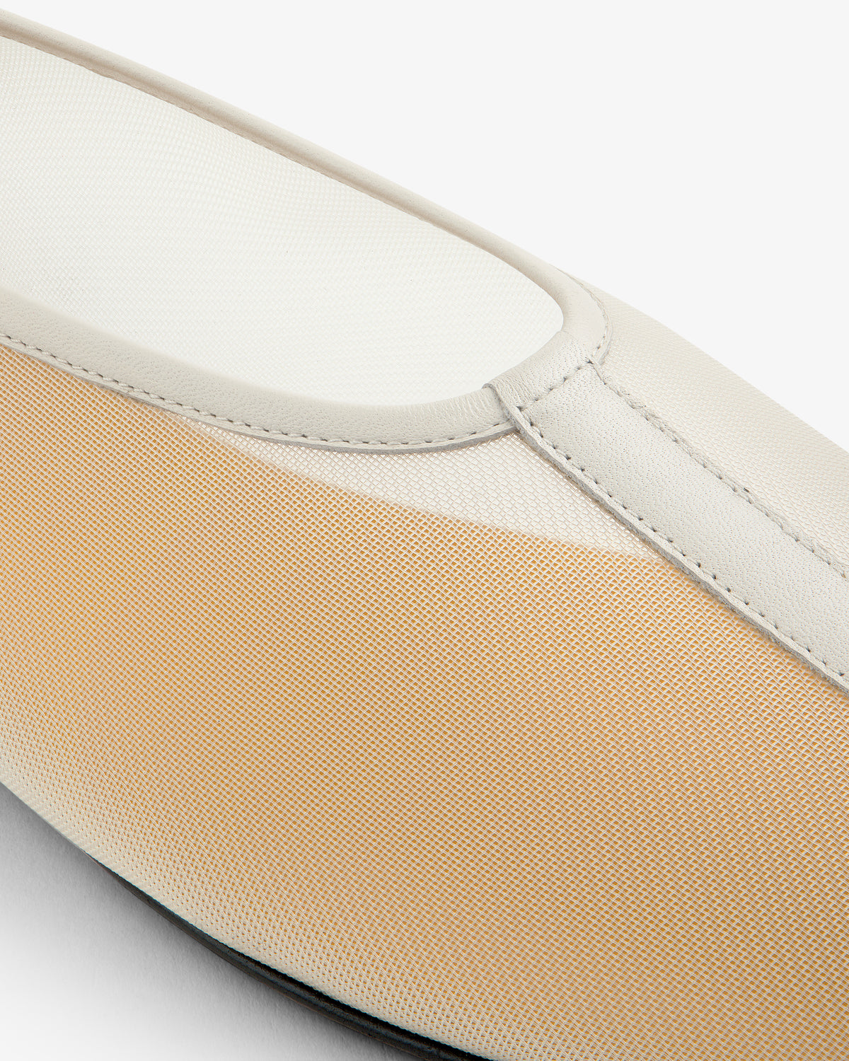 Close-up of the Mesh Ballet Flat, a beige and white slip-on with textured fabric and smooth leather trim.