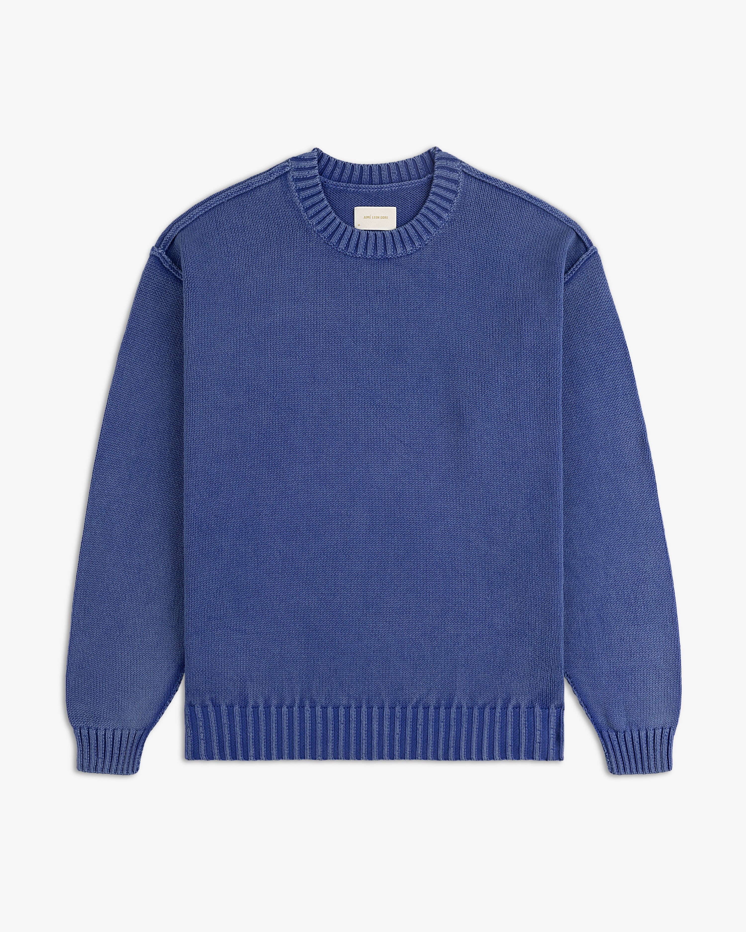 Washed Inside Out Sweater in blue with ribbed collar, cuffs, and hem, shown laid flat on a white background.
