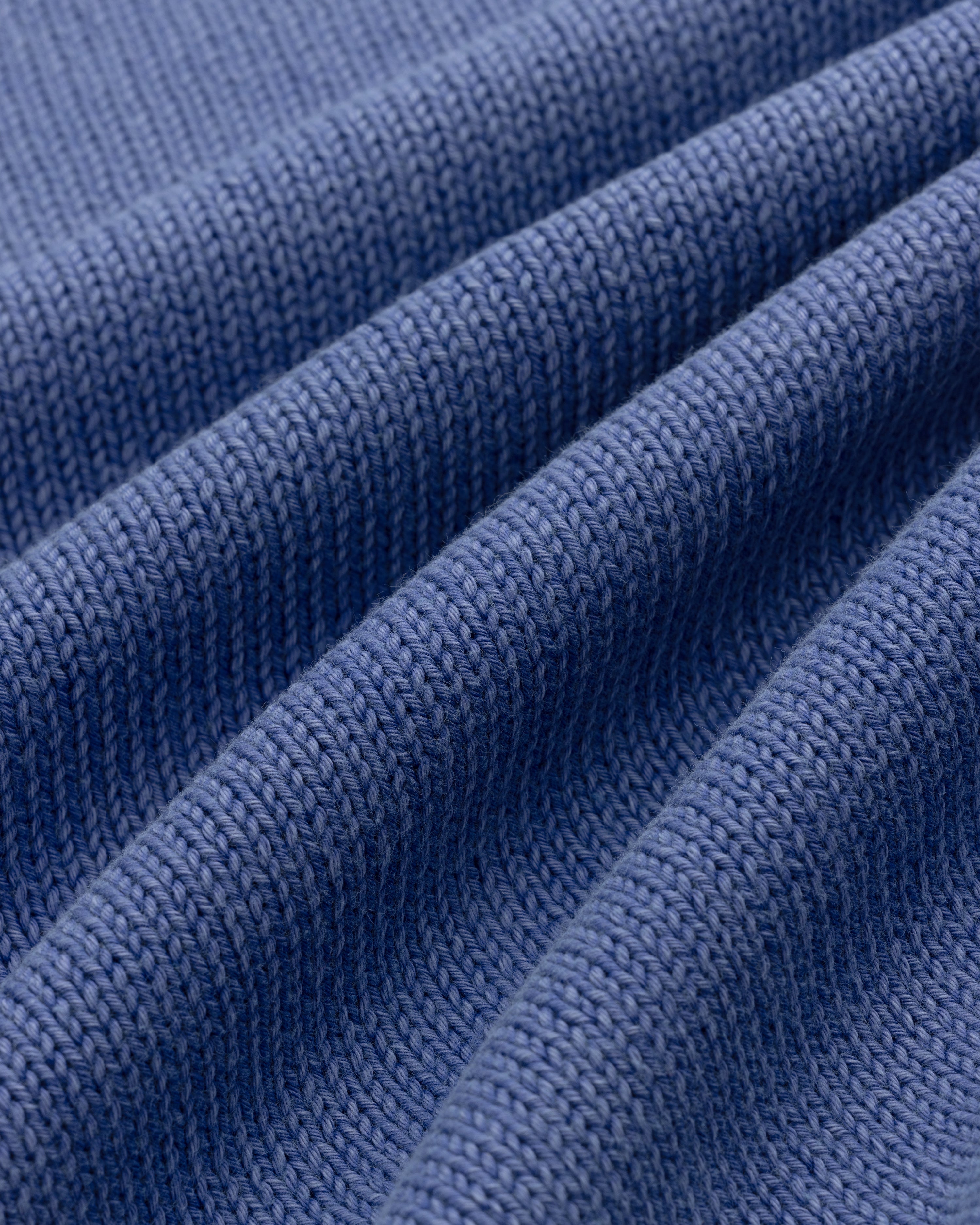 Close-up of the Washed Inside Out Sweater in blue, highlighting its detailed knit texture and folds.