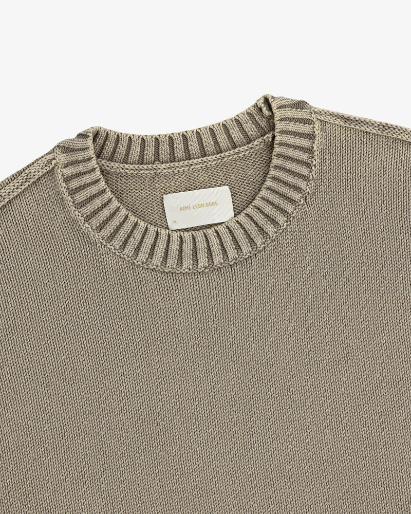 A close-up of the Washed Inside Out Sweater in beige, featuring a ribbed crew neck and visible white collar label.