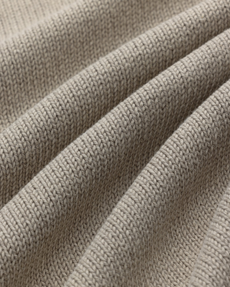 Close-up of the Washed Inside Out Sweater's beige ribbed knit fabric with soft, evenly spaced folds.