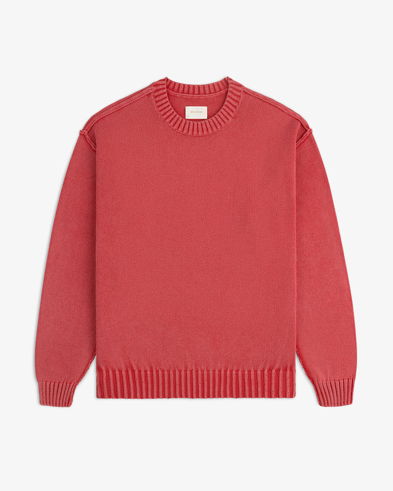 A Washed Inside Out Sweater with long sleeves and a crew neck in red is laid flat on a white background.