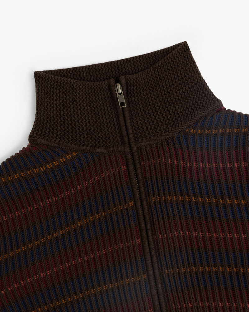 Close-up of the Multi Color Knit Track Sweater with ribbed stripes, high collar, and central zipper in brown, maroon, blue, yellow.