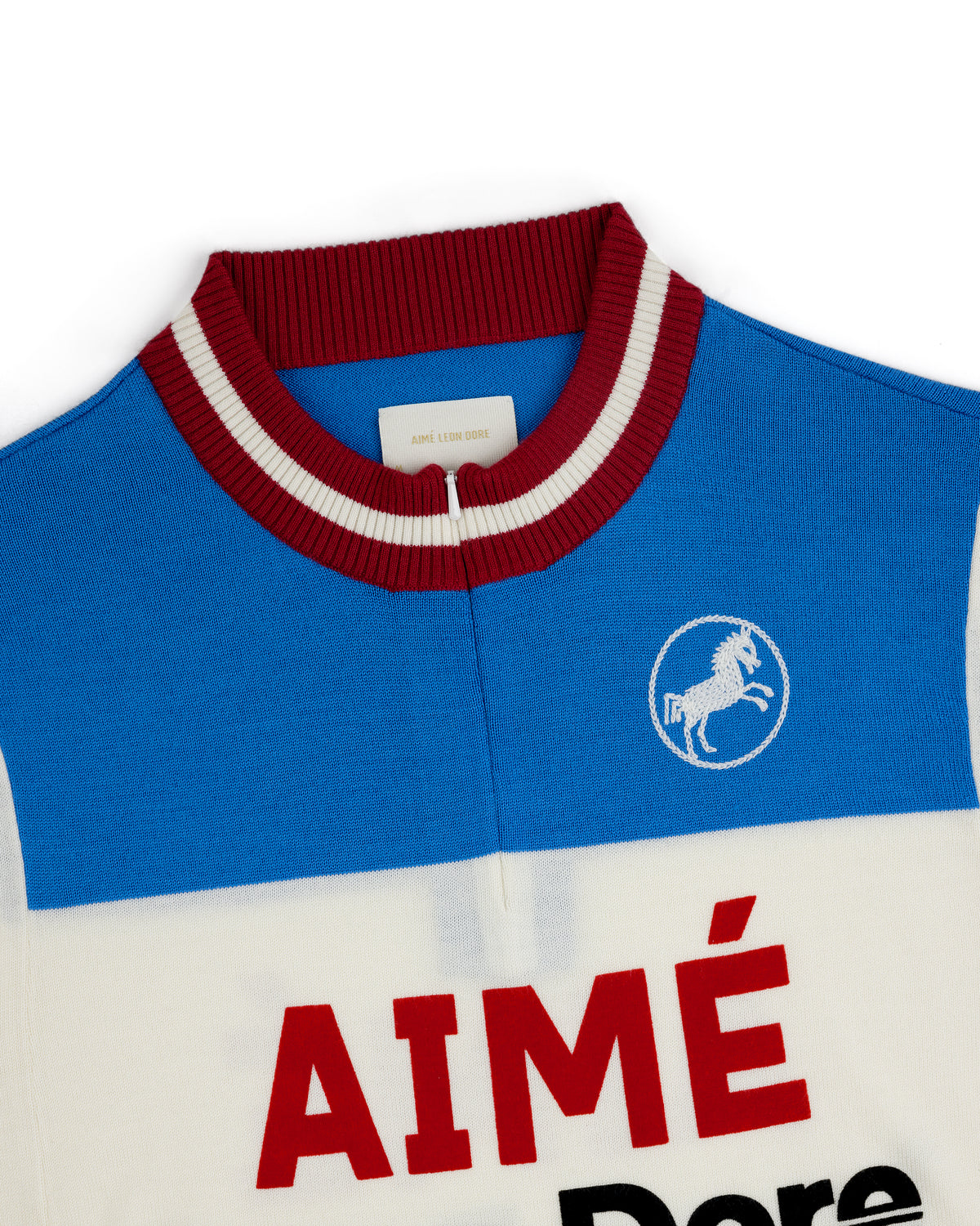 Blue and white Merino Wool Cycling Jersey with red collar, AIMÉ text, and white horse emblem on the chest.