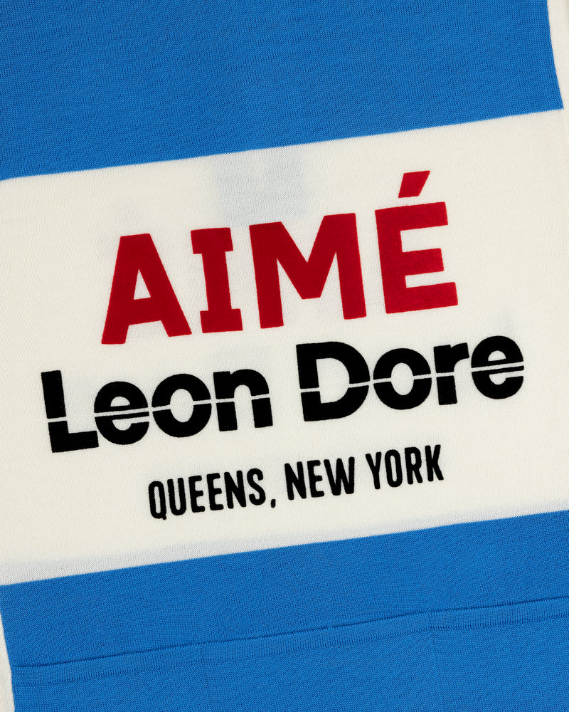 Close-up of a Merino Wool Cycling Jersey with AIMÉ Leon Dore QUEENS, NEW YORK on blue and white stripes.
