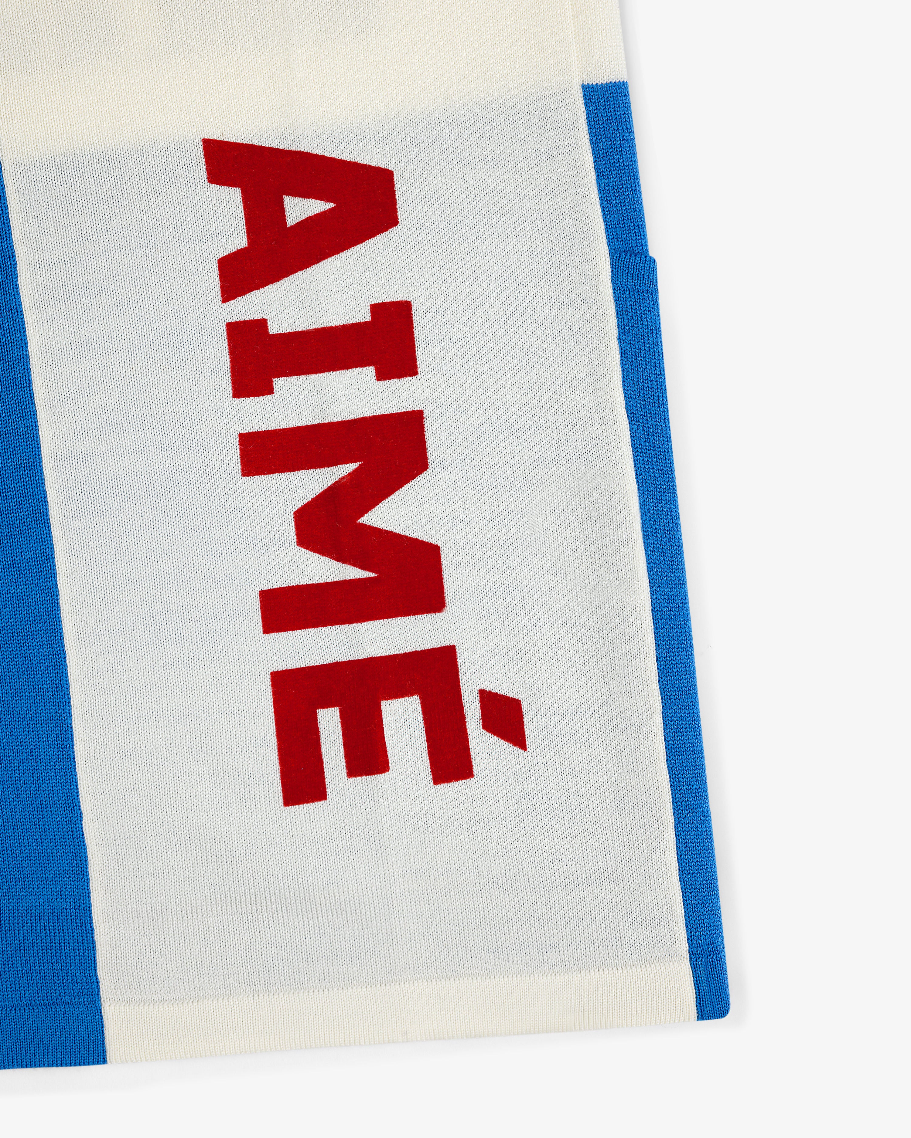 A white and blue Merino Wool Cycling Jersey with AIMÉ in bold red letters printed vertically.
