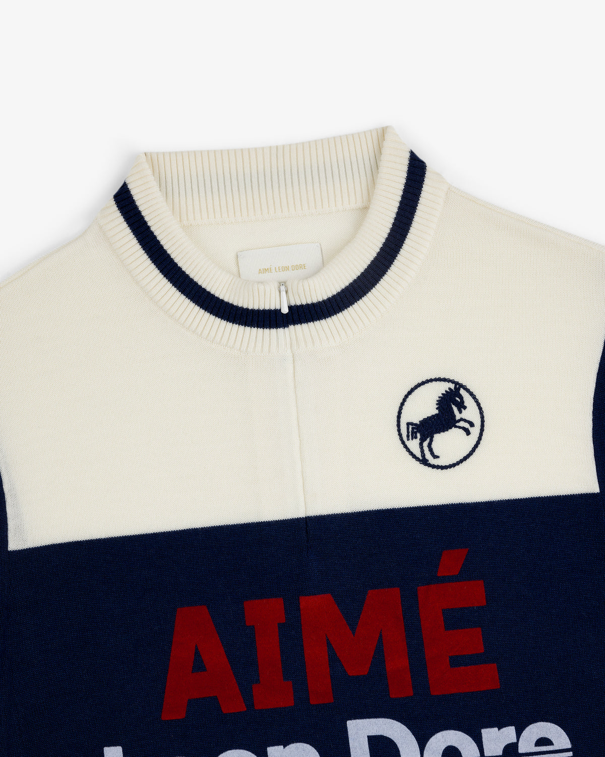 Close-up of a Merino Wool Cycling Jersey with AIMÉ text and an embroidered horse logo on the chest.