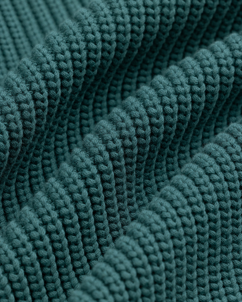 Close-up of textured, teal knit fabric on the Reversible Knit Bomber Jacket with thick, raised ribbing.