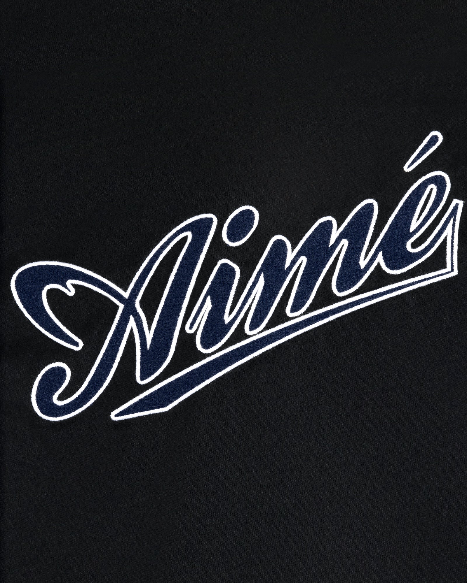 White outlined script word Aimé on black, in bold cursive, featured on the Reversible Knit Bomber Jacket.