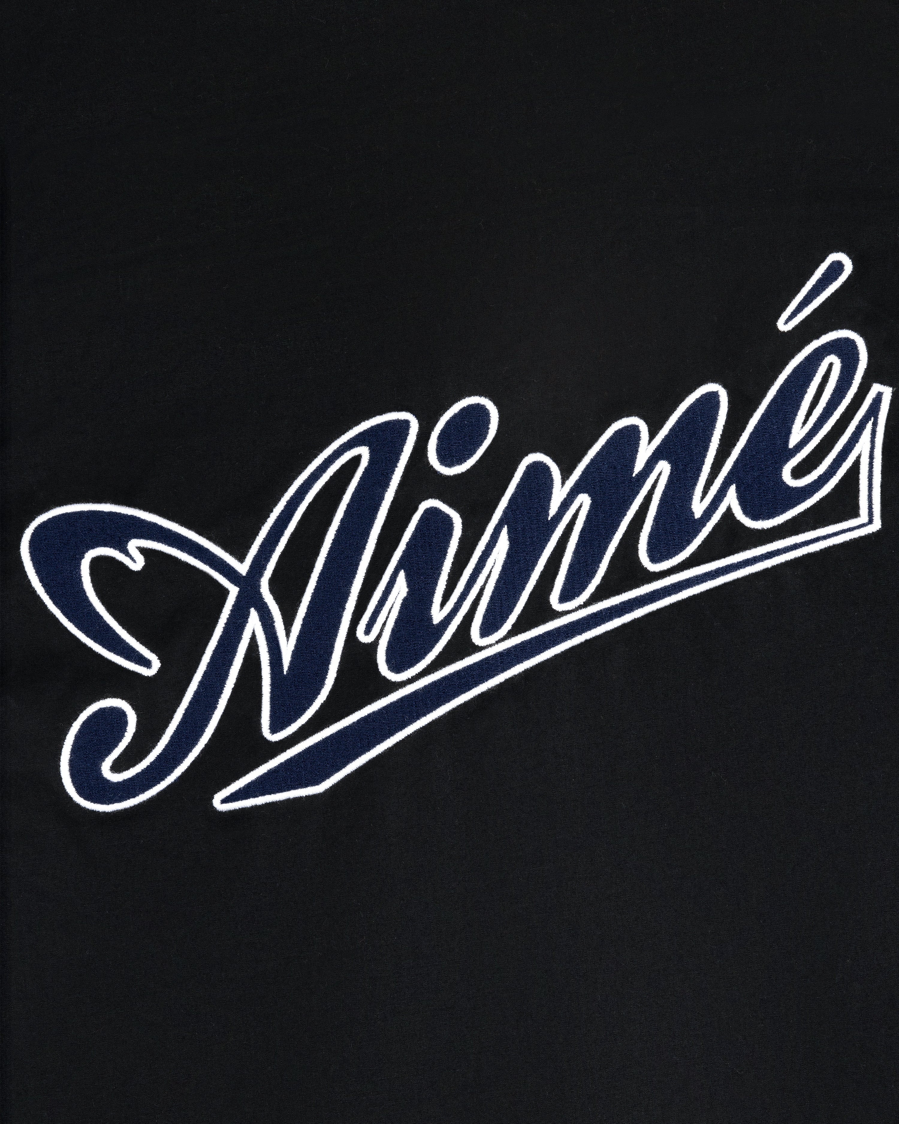 White outlined script word Aimé on black, in bold cursive, featured on the Reversible Knit Bomber Jacket.