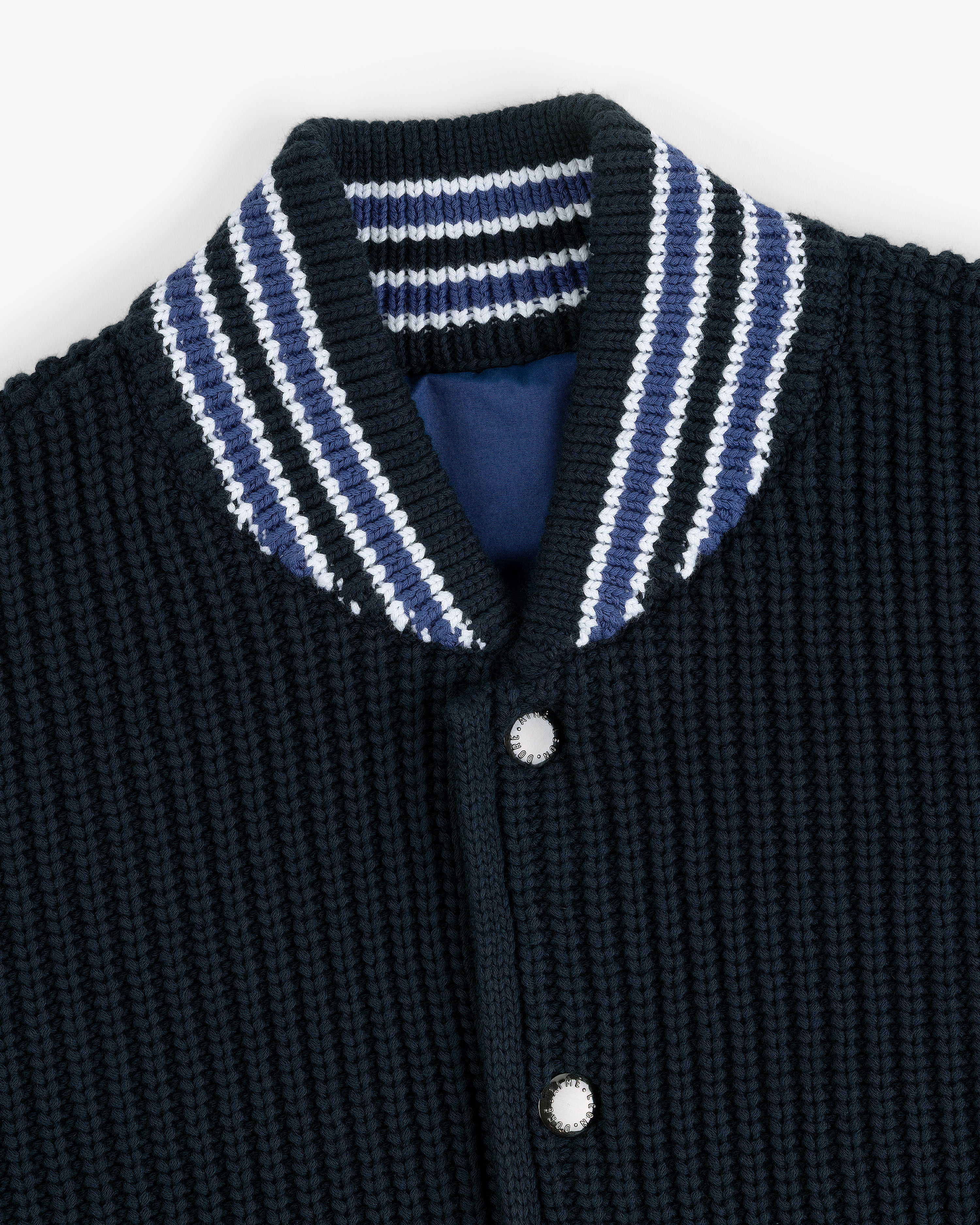 Close-up of the Reversible Knit Bomber Jacket with a blue, white, and black striped ribbed collar and snap buttons.