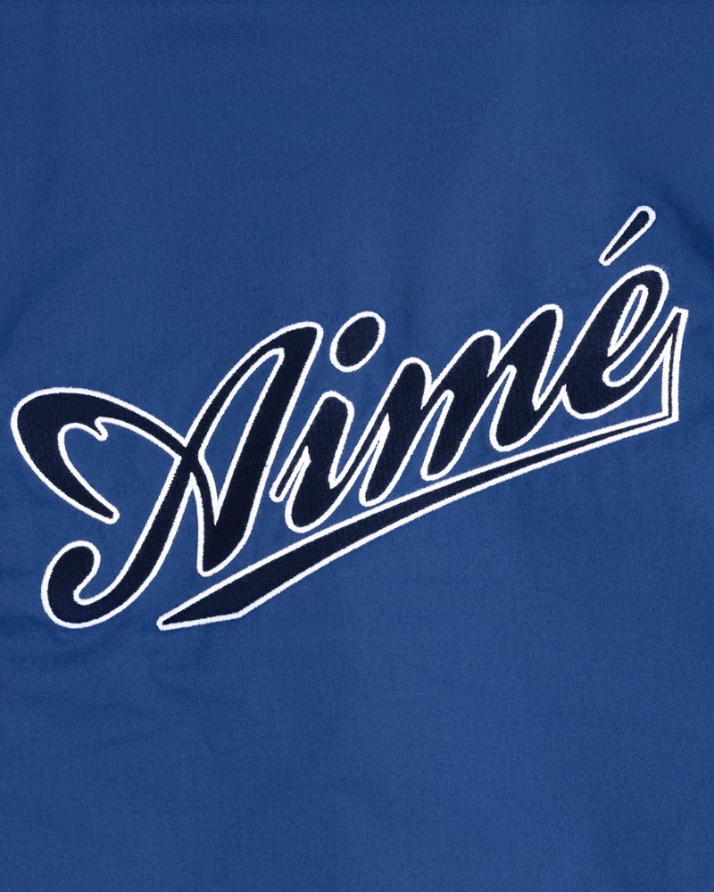 Blue fabric Reversible Knit Bomber Jacket with "Aimé" in large, white, cursive outlined letters across the front.