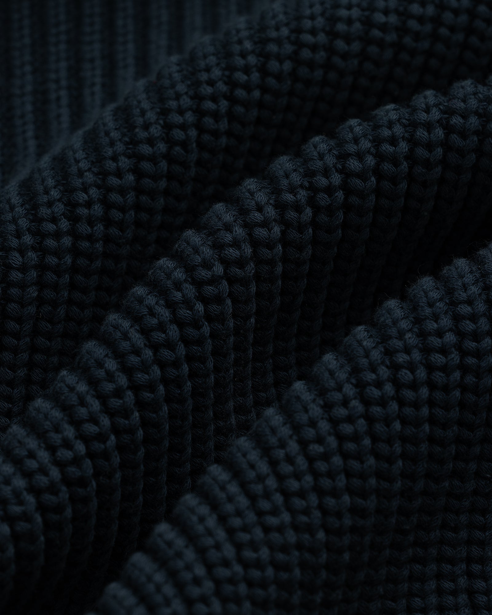 Close-up of the dark blue ribbed texture on the Reversible Knit Bomber Jacket, showing visible raised ridges.