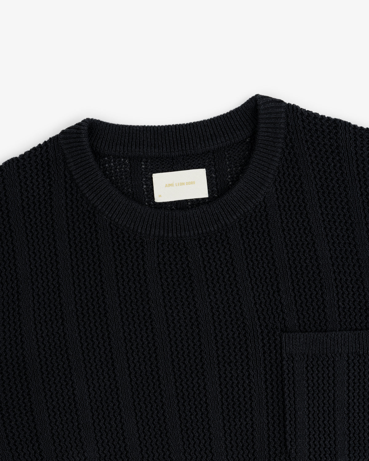Racking Stitch Crewneck Sweater in black with a chest pocket, round neckline, shown on a white background.
