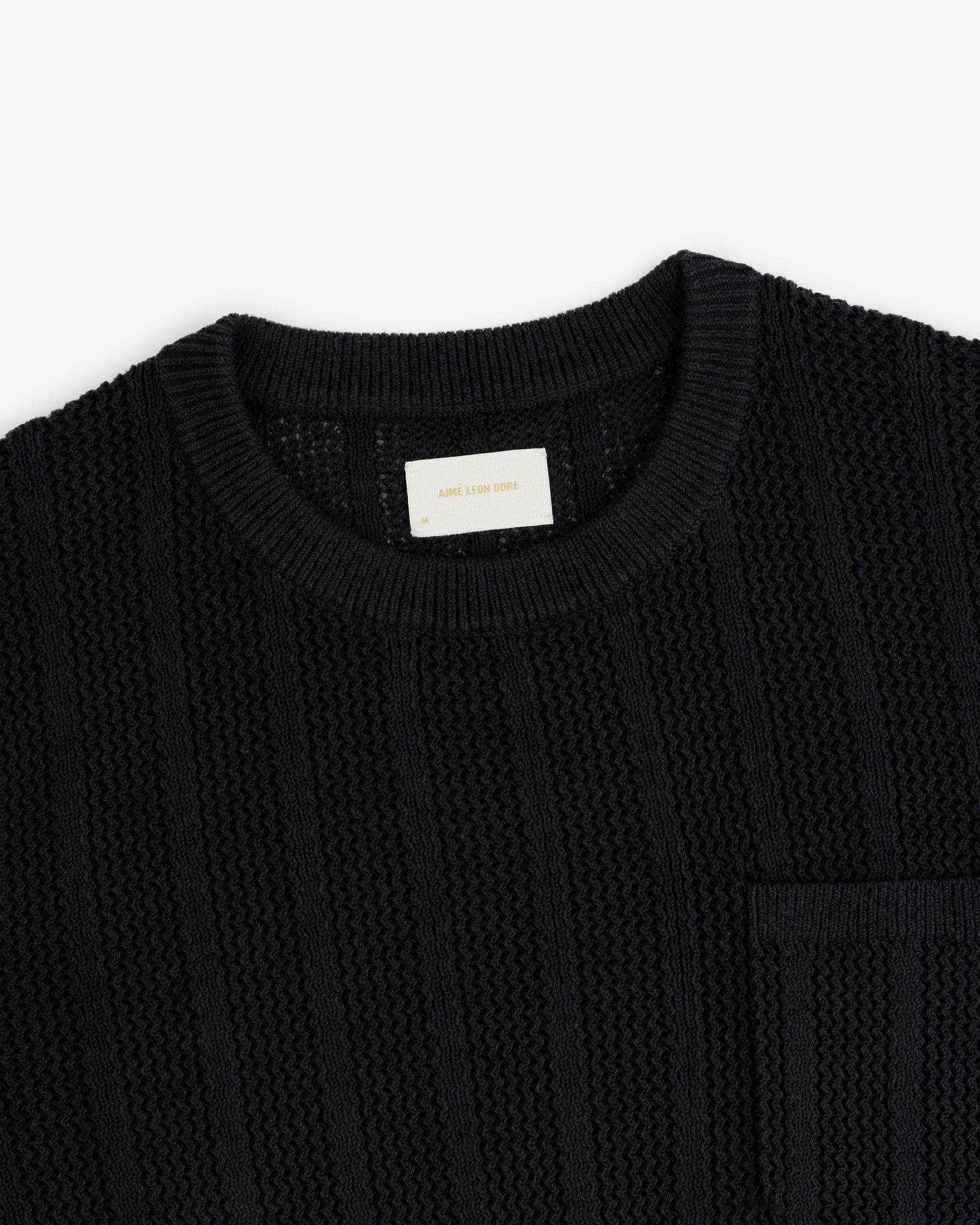 Racking Stitch Crewneck Sweater in black with a chest pocket, round neckline, shown on a white background.