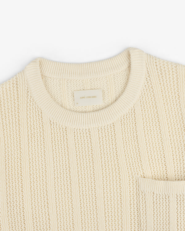 The Racking Stitch Crewneck Sweater is beige with a textured knit, round neckline, and chest pocket on a white background.