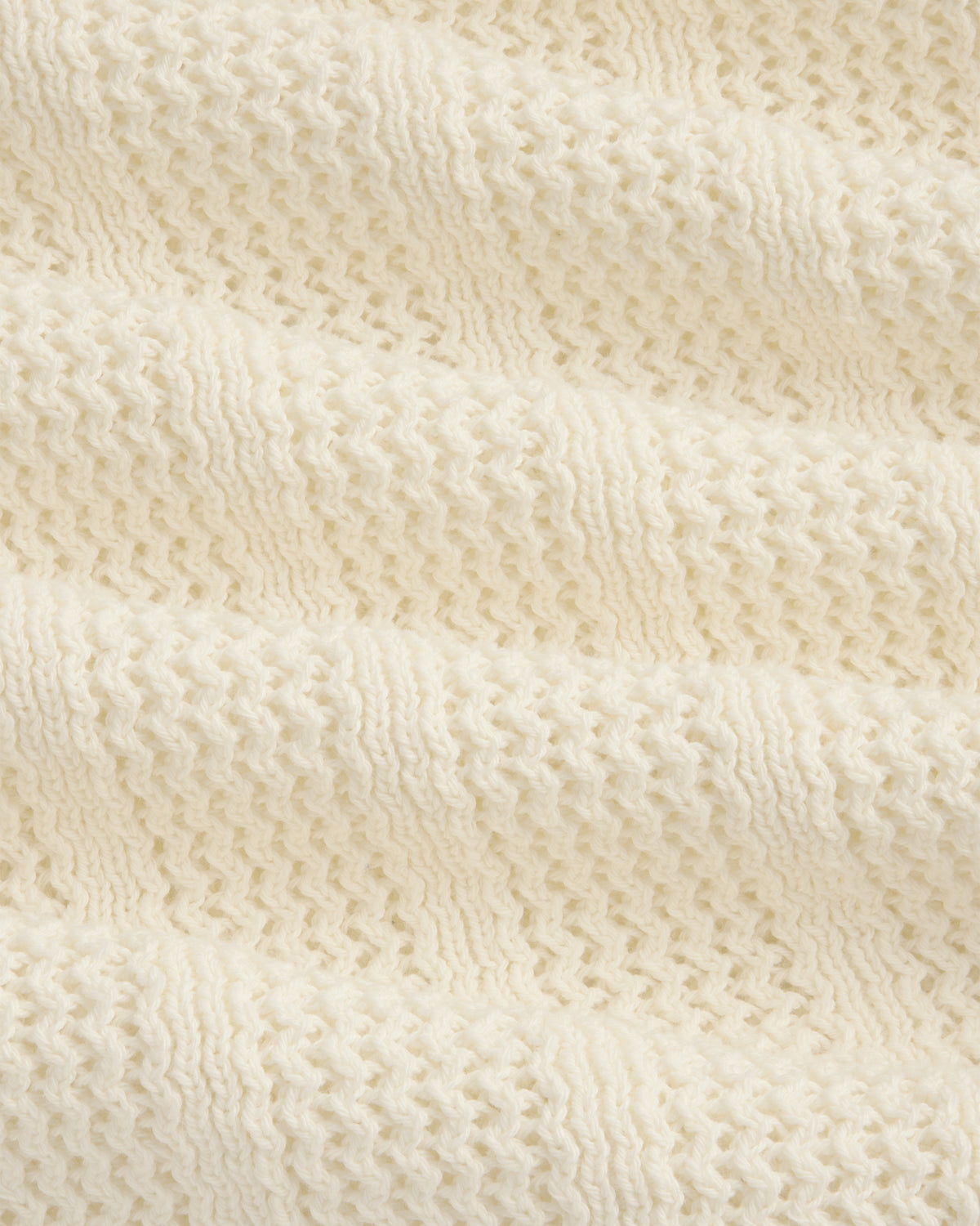 Close-up of the Racking Stitch Crewneck Sweater's soft, cream knit with a textured, wavy pattern.