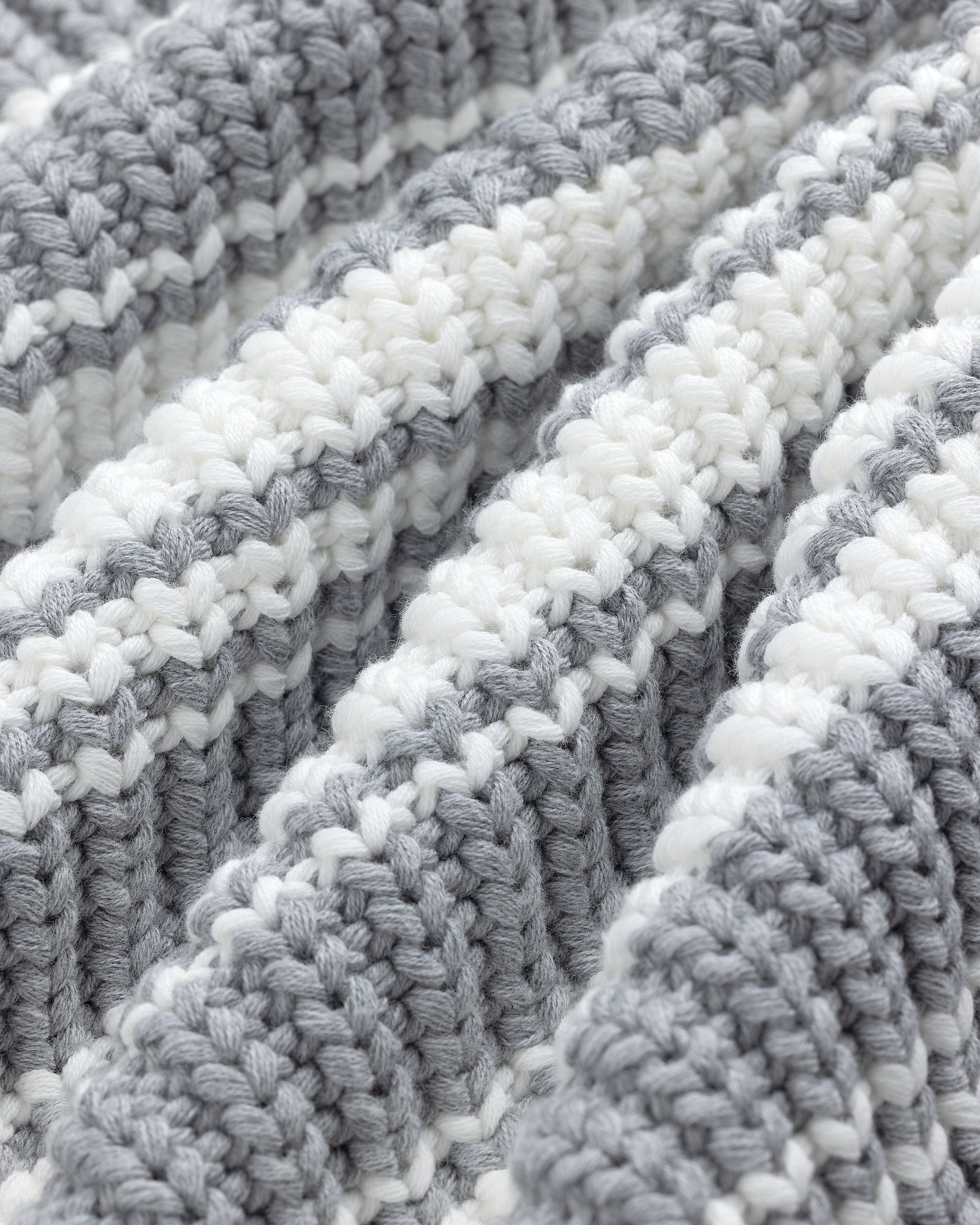 Close-up of the Striped Crewneck Sweater, featuring gray and white stripes and textured knit for a soft, cozy feel.