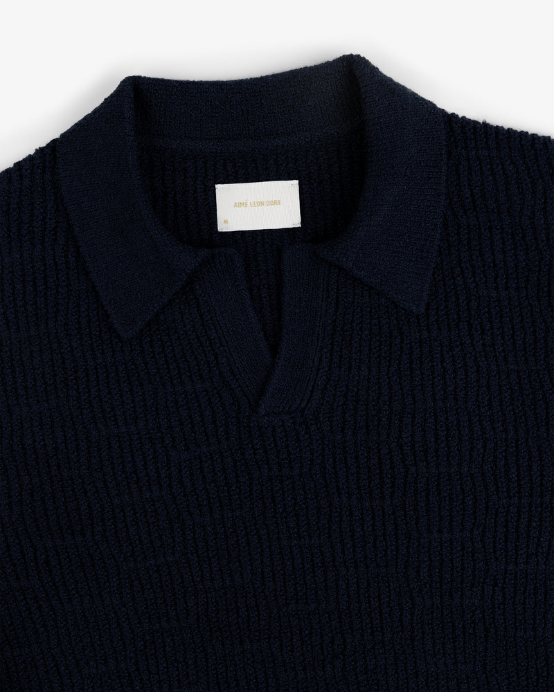 Navy Long-Sleeve Boucle Polo with ribbed knit, V-neck, collar, and a white label inside the collar.