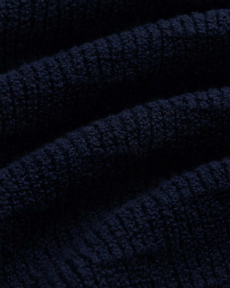 Close-up of the Long-Sleeve Boucle Polo in dark blue, showing its visible ribbed texture and soft, raised ridges.