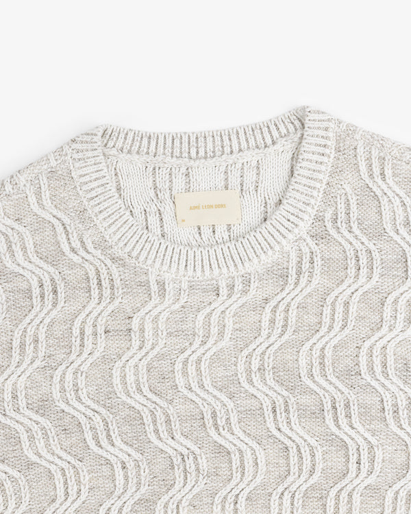 Linen Blend Cable Knit Sweater in light gray with a wavy white pattern and ribbed crew neckline, shown from above.