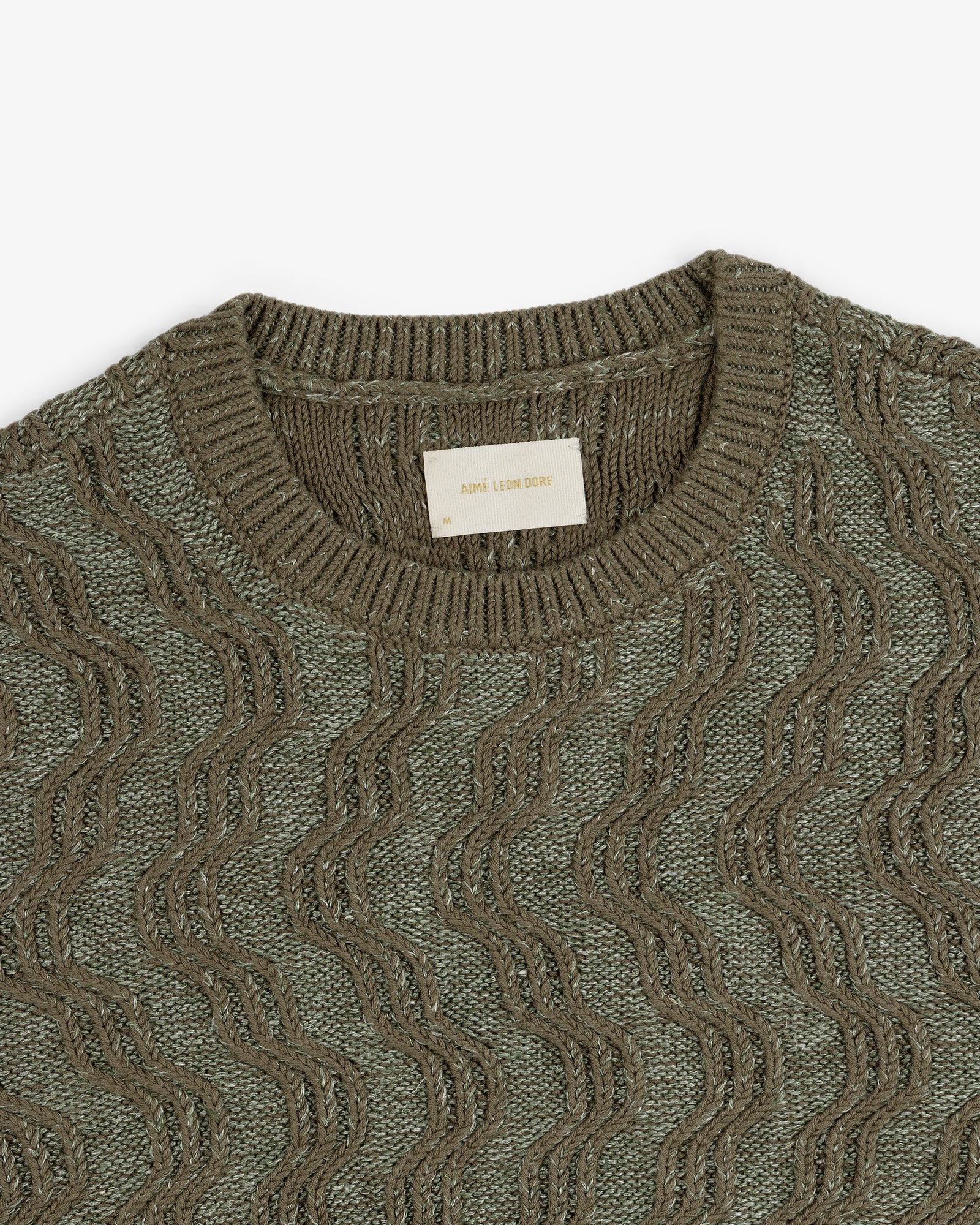 Linen Blend Cable Knit Sweater in olive green with a wavy texture and crew neck, top view.