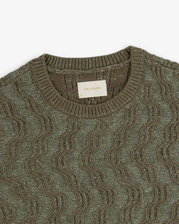 Linen Blend Cable Knit Sweater in olive green with a wavy texture and crew neck, top view.