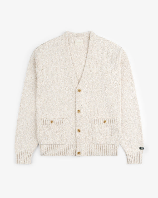 The Cotton Slub Cardigan is cream-colored with a textured finish, two front pockets, and three buttons, shown laid flat.