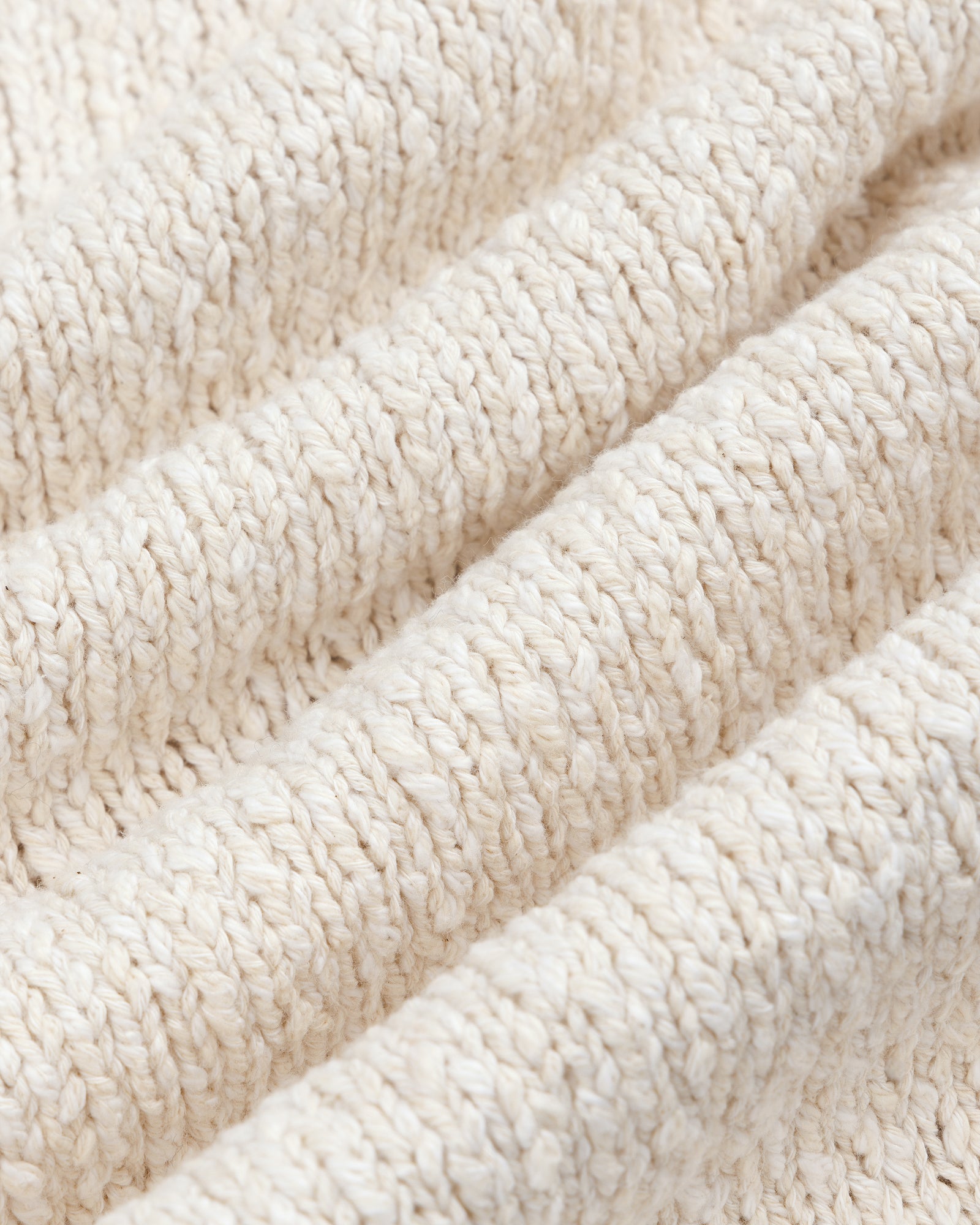 Close-up of a beige Cotton Slub Cardigan, featuring textured knit with visible horizontal ridges and soft fibers.