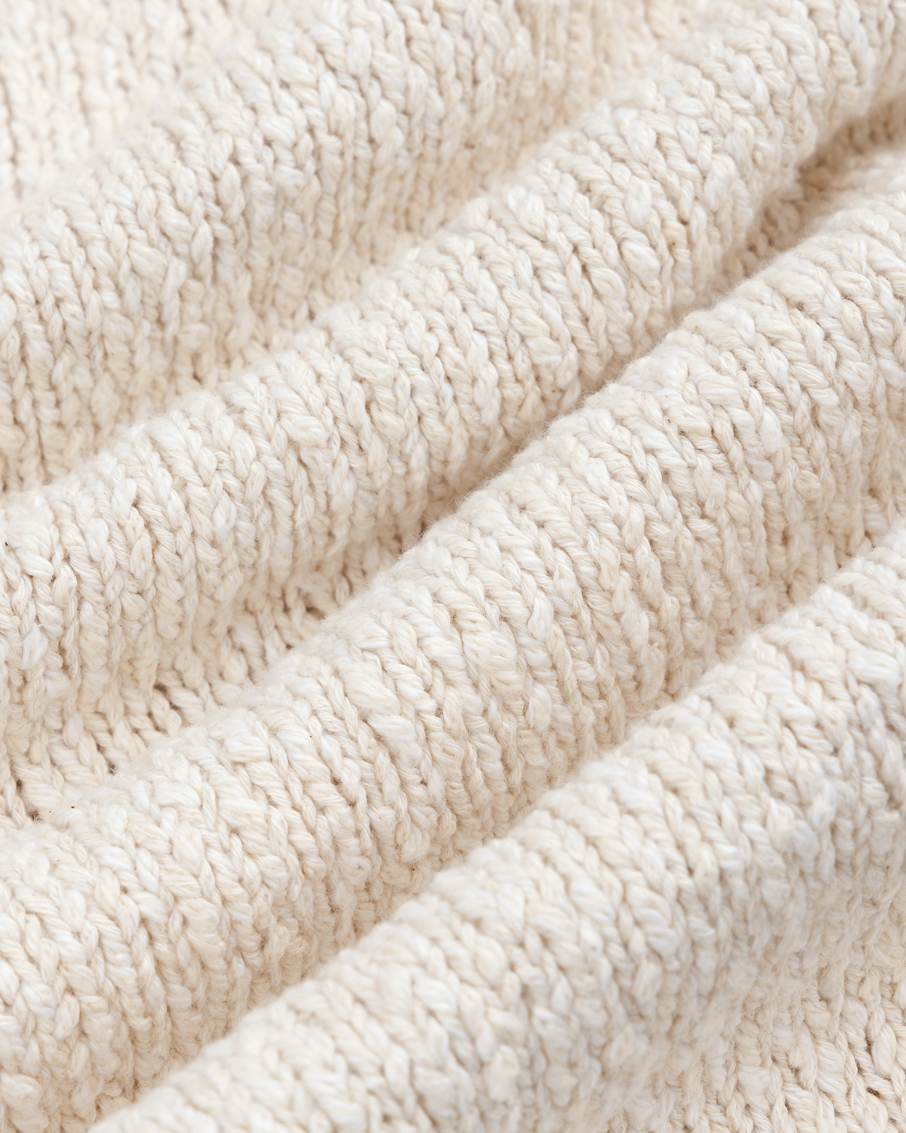 Close-up of a beige Cotton Slub Cardigan, featuring textured knit with visible horizontal ridges and soft fibers.