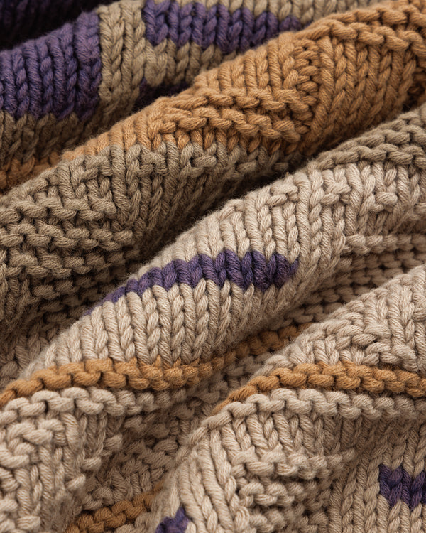 A close-up of the Simaía Crewneck Sweater with tan, brown, and purple striped textured knit fabric.